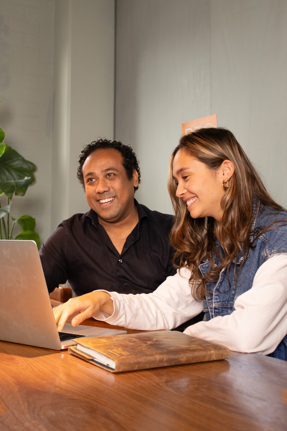 Twee recruiters bekijken samen lachend een laptop tijdens een kennismakingsgesprek bij Rec2Rec